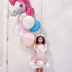 Little heroes birthday party: little girl posing with balloons