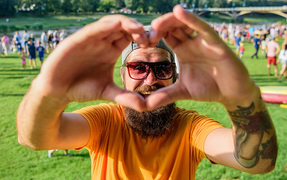 Smiling bearded man making a heart with his hands