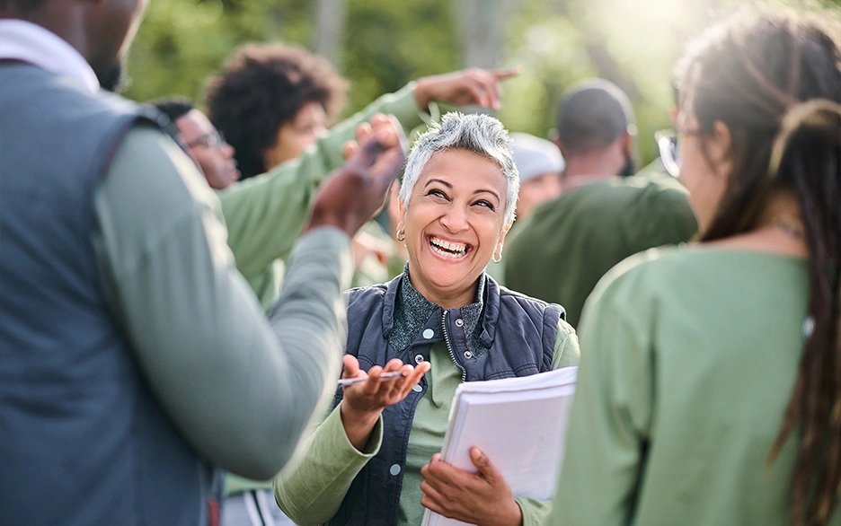 Smiling woman with clipboard managing a team of volunteers