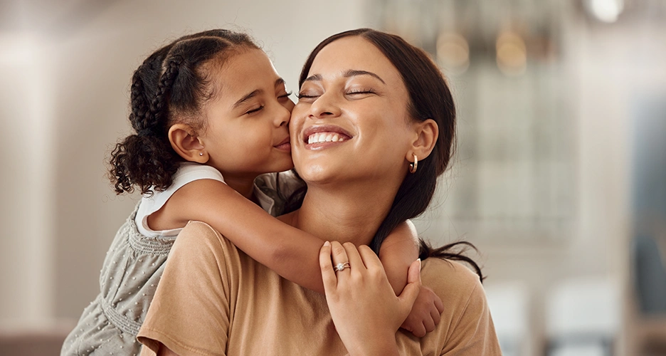 Daughter hugging and kissing mother