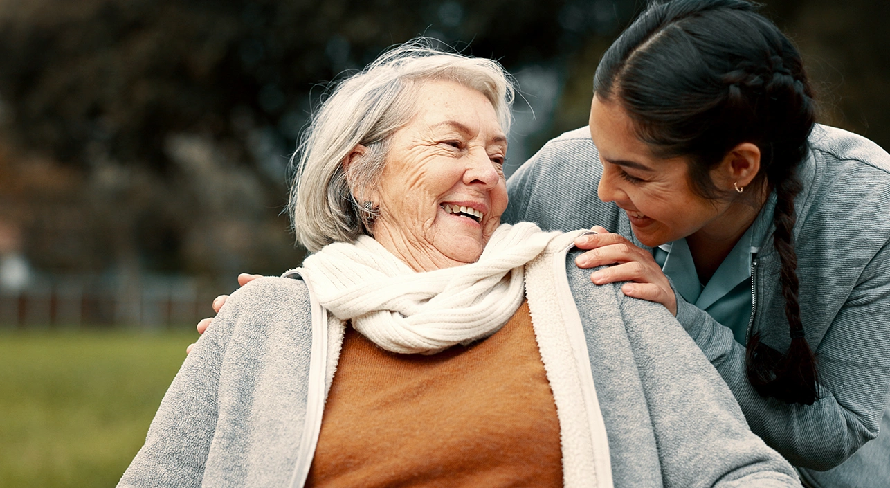 Femme âgée souriant à une femme plus jeune